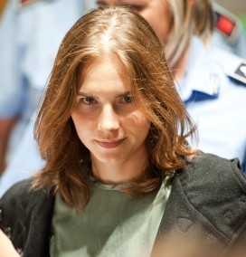 Photo of a grimly smiling Amanda Knox in courtroom