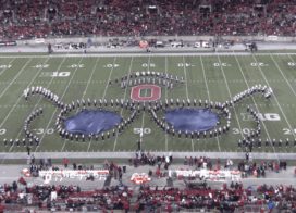 A marching band forms aviator sunglasses on a football field